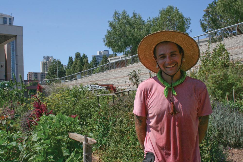 Seeds@City student Jake Anzarouth poses in front of the Urban Farm.