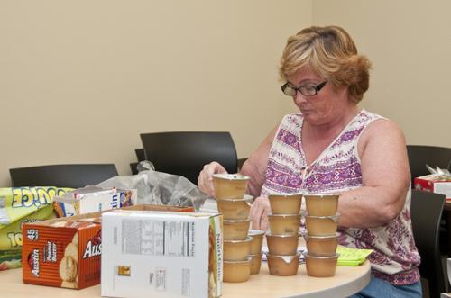 Sandra Hostette prepares lunches for students who use the services provided by the food pantry.   David Wells, City Times