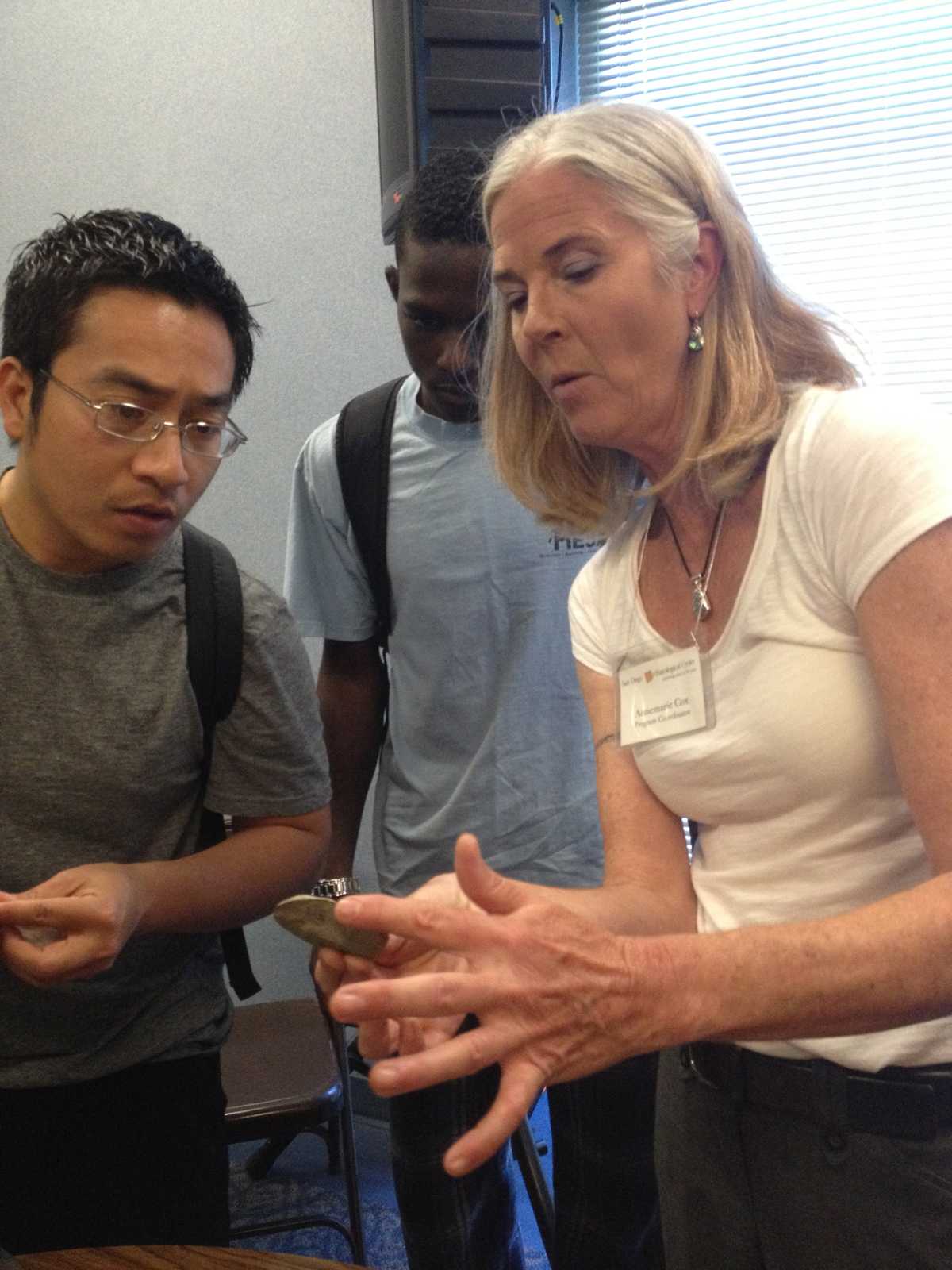 Program coordinator Annemarie Cox shows students a flint from a dig site in San Diego after her presentation on April 3.  Mariel Mostacero, City Times