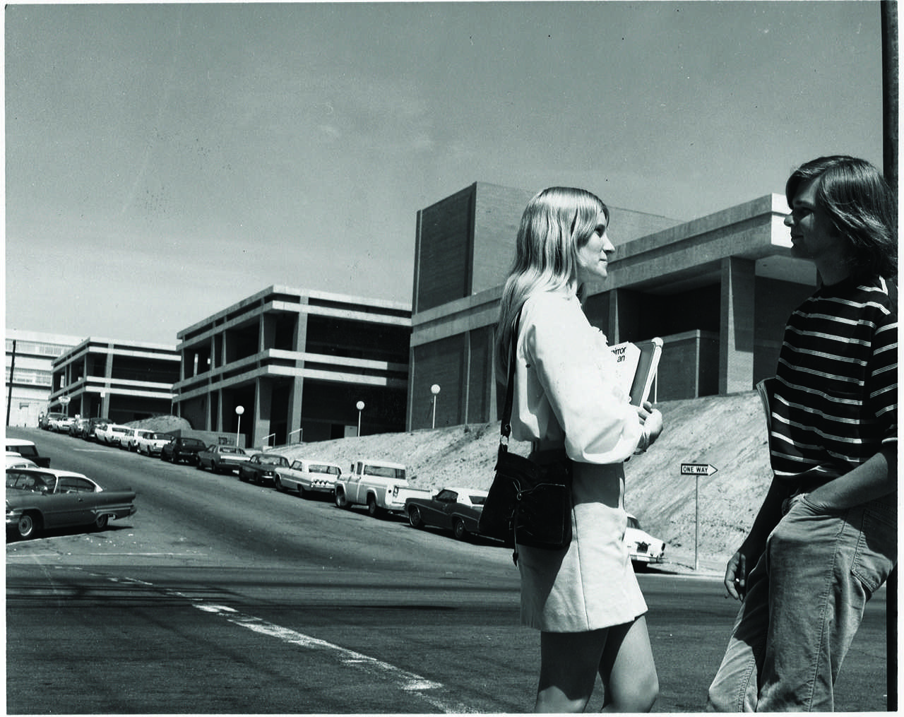 Two students stand across the street from City Colleges new theater in the 1970s. The complex, located on C Street, is now known as the Saville Theatre. Photo courtesy of the City Times archive.