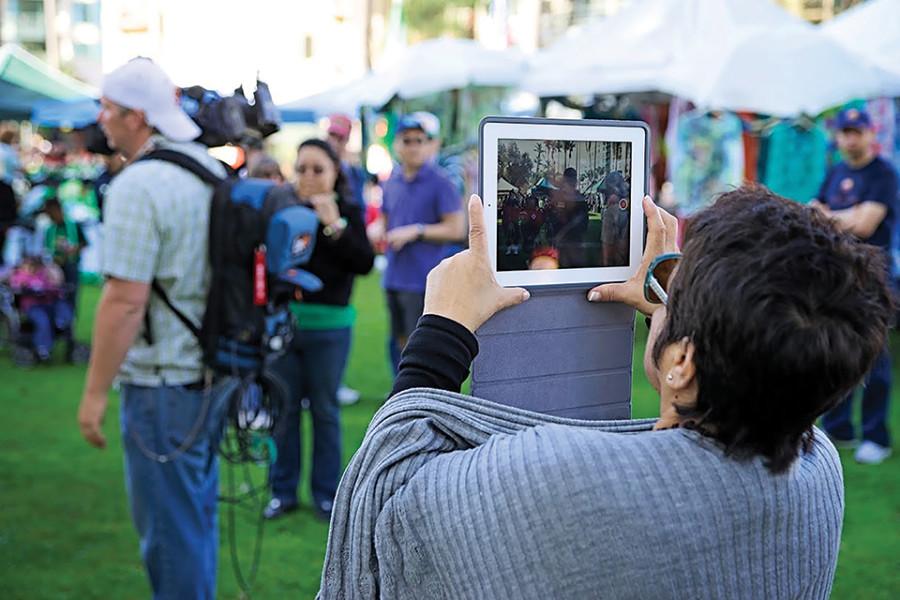 A person recording a St. Patricks Day event on an iPad Photo credit: Troy Orem