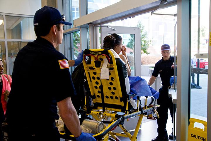 A 19-year-old female student is wheeled out of MS building by paramedics following an assault on Oct. 9. Photo credit: Troy Orem