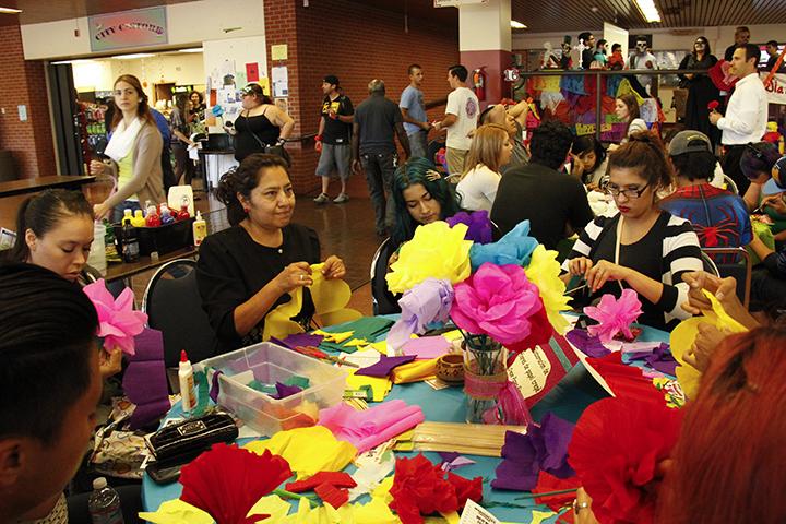 Students create crepe paper flowers to adorn Dia de los Muertos altars during the Oct. 30 event in the cafeteria. Photo credit: Celia Jimenez