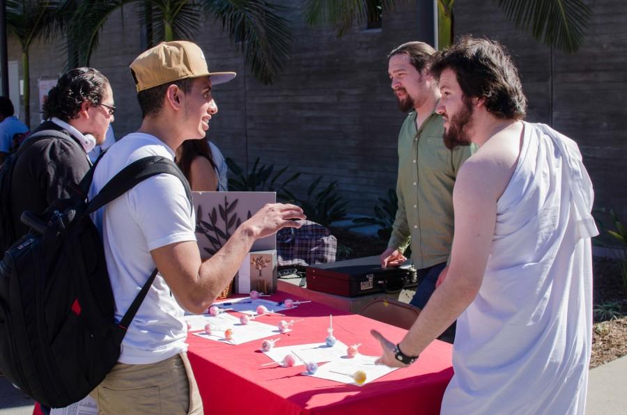 Edward Yannaccone (right), President of the Philosophy and Cameron Kiplinger, Vice President, look to recruit sophomore mechanical engineering student Luis Garcia (left) during Club Rush on Feb. 12. Photo credit: Richard Lomibao