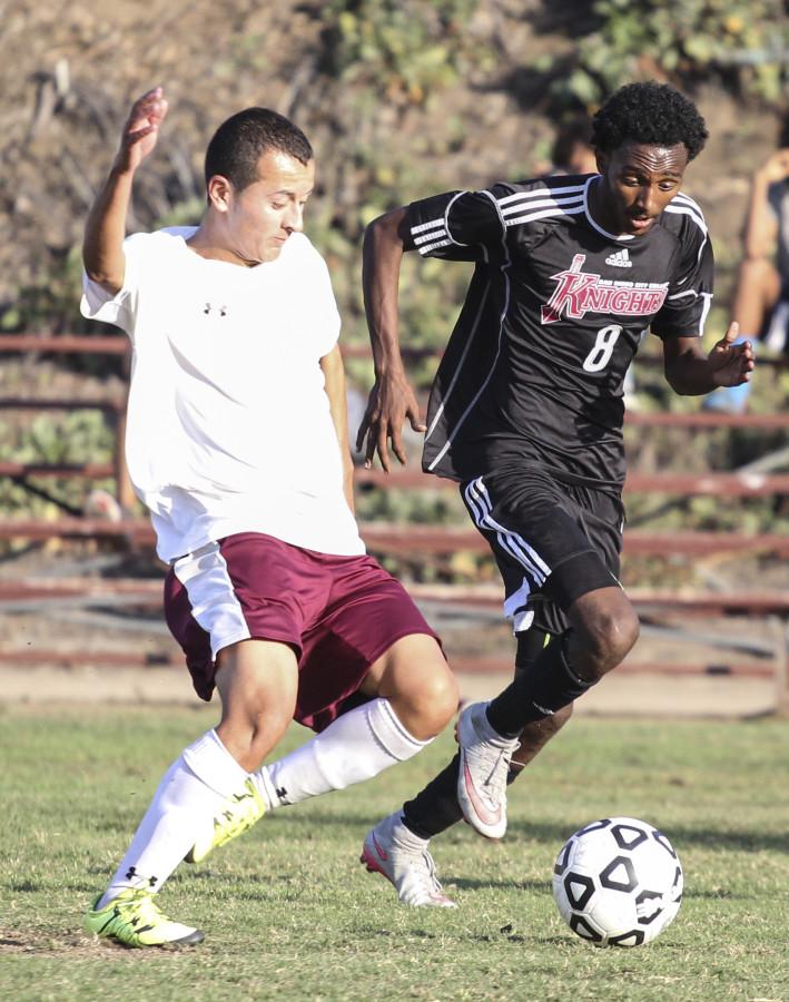 San Diego City College men’s soccer midfielder Tadey Anteneh trails Victor Valley Rams freshmen forward Marvin Soriano to stop his advancement to the Knights’ goal during their Oct. 23 game on the City College soccer field. Photo credit: Celia Jimenez