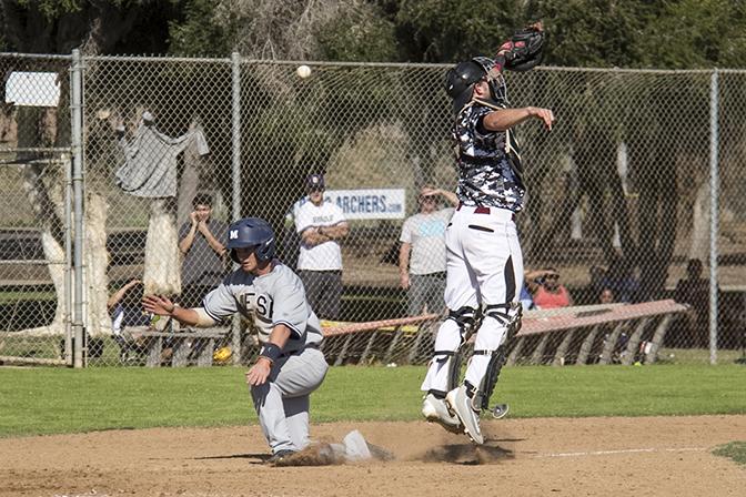Sophomore infielder Alex Emerick (left) and freshman catcher Wyatt Logan (right)  battle to get first to the home plate. Emerick hits first and scores the sixth run for the Olympians during the ninth inning at Morley Field on Feb. 27.  Photo  credit: Celia Jimenez 


