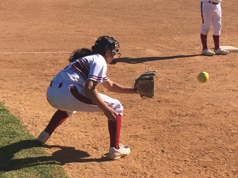 Softball player catches ball while warming up.