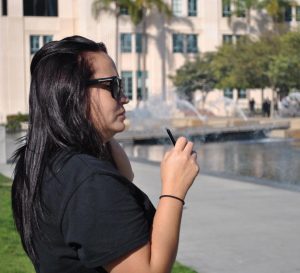 A woman takes a drag off of a vaping device in downtown San Diego