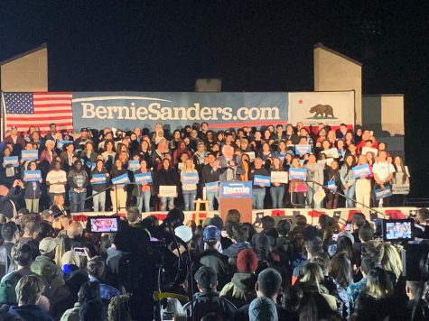 Bernie Sanders with a crowd in a podium at San Ysidro High School.