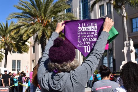 Women holding a purple sign. that reads “The fault was not mine nor where I was, nor what I was wearing” in Spanish.