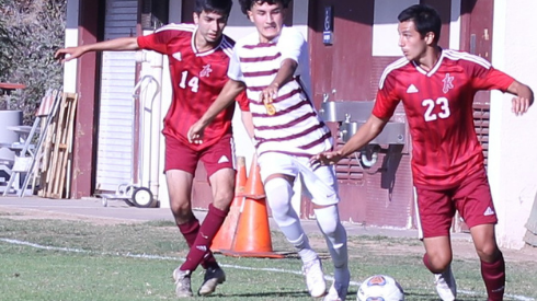 (From right) Roberto Perez advancing the ball downfield against Victor Valley College Aaron Felix with teammate Javier Monarrez trailing.
