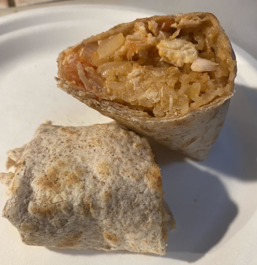 Chicken and rice wrapped in a tortilla on a white plate.