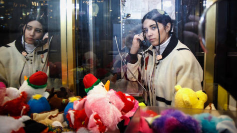 Jackie Mendoza on a payphone with toys in foreground