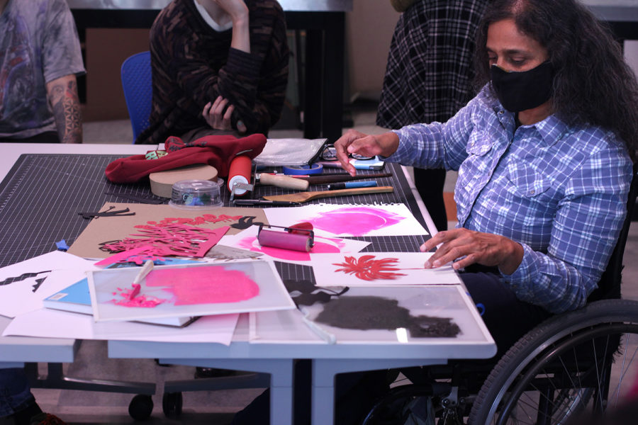 Artist+Bhavna+Mehta+demonstrates+cut+paper+art+and+printmaking+to+a+group+of+people.