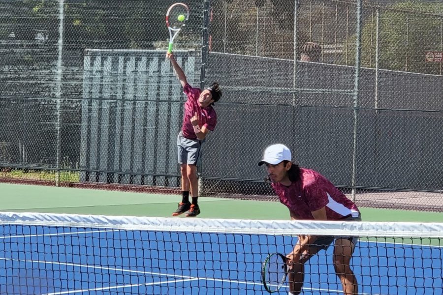 Eduardo Castillo (left) serving up against Riverside in their doubles match in the regional first round with his partner Carlos Robles (right) at home.