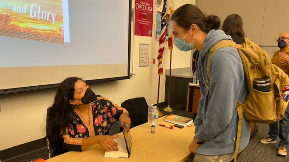 Student Alexander Daumas gets his book signed by author Reyna Grande at City College