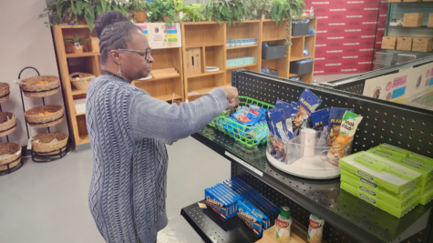 Marie Lindsey, Knight’s Table administrative assistant, restocks shelves with snacks available for students at City College’s food pantry Tuesday, March 14, 2023. Photo by Sven Domingos/City Times Media