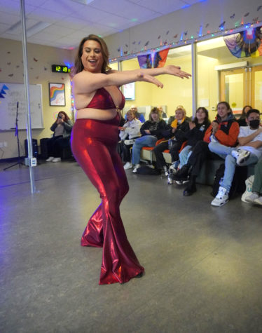 Drag performer dancing for student audience