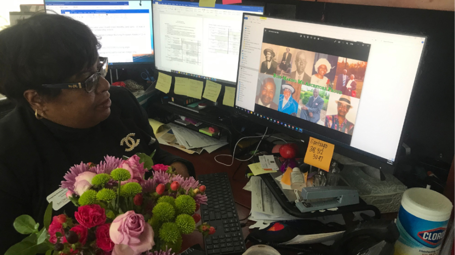 Dometrives+Armstrong+pulls+up+a+picture+of+her+relatives+who+inspired+her+after+placing+flowers+she+received+as+a+gift+from+a+student+on+her+desk
