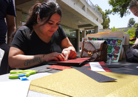 Fanny Benitez, an education major, decorates her graduation cap, dedicating it to her first baby