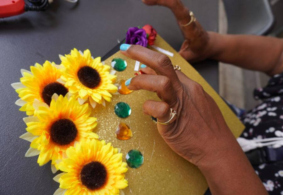Kelley Westley uses sunflowers and colorful rhinestones to enhance her graduation cap in May 16, 2023