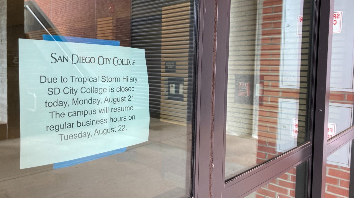 A City campus closure sign inside a window of the AH Building entrance