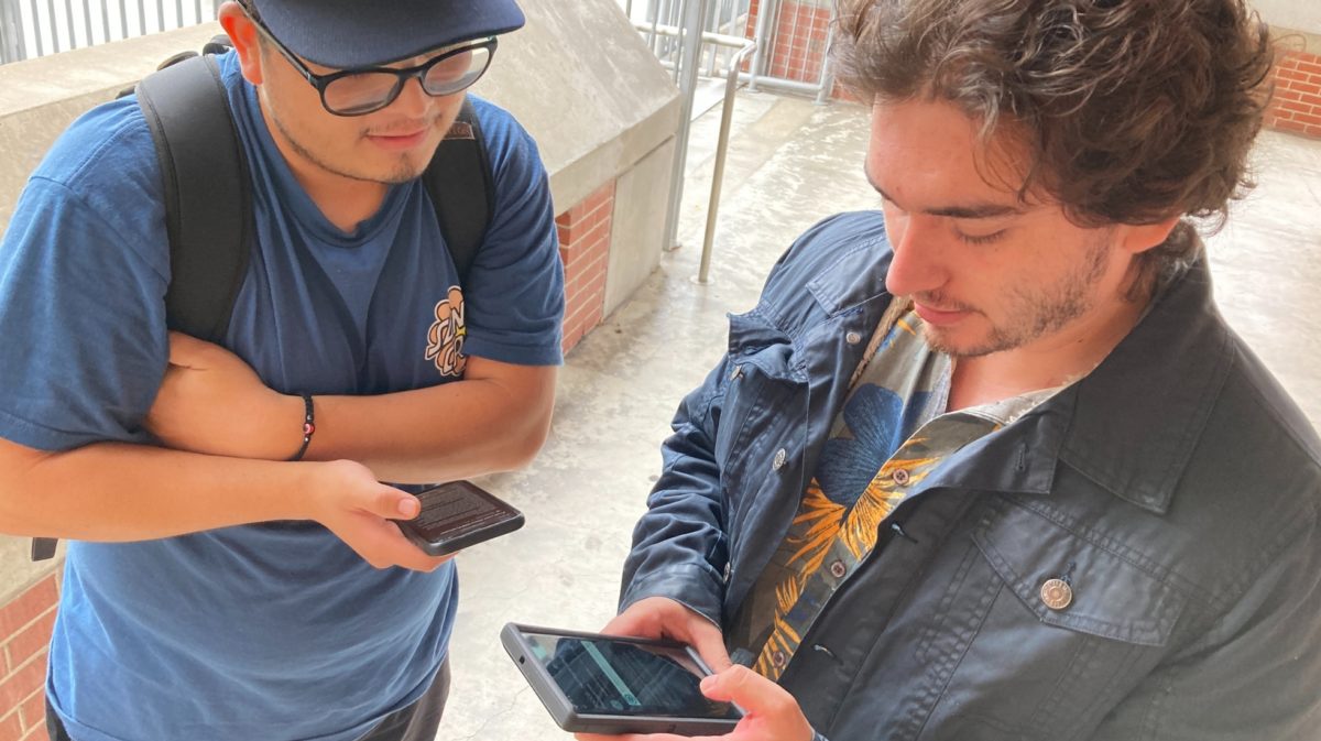 City students Steven Garcia,left, and Sean Murphy, right, search through their phones