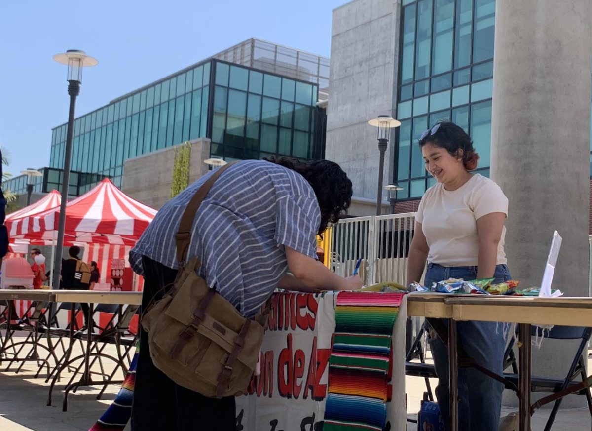 Business major Marcela Guerrero talks to a student signing up for Movimiento Estudiantil Chican@ de Aztlan (MEChA). It was one of approximately 17 clubs recruiting at the Club Rush Carnival, according to Student Affairs Coordinator Lori Oldham, August 24, 2023. Keila Menjivar/City Times Media