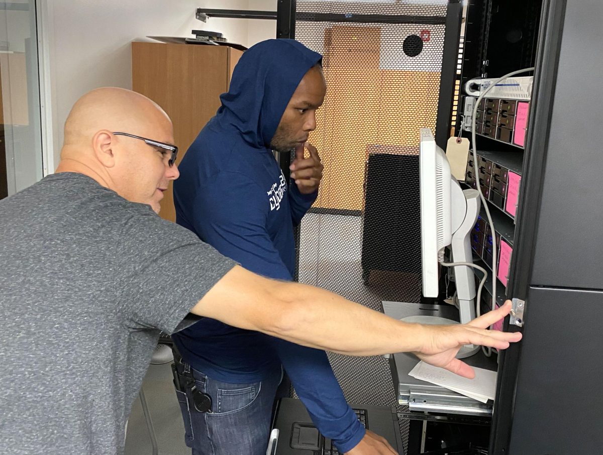 Program Director of Cyber Defense and Analysis David Kennemer, left, and Instructional Lab Technician Terrell McClain, right, set up virtual machines outside of a classroom, Thursday, Oct. 12, 2023. Photo by Eve McNally/City Times Media
