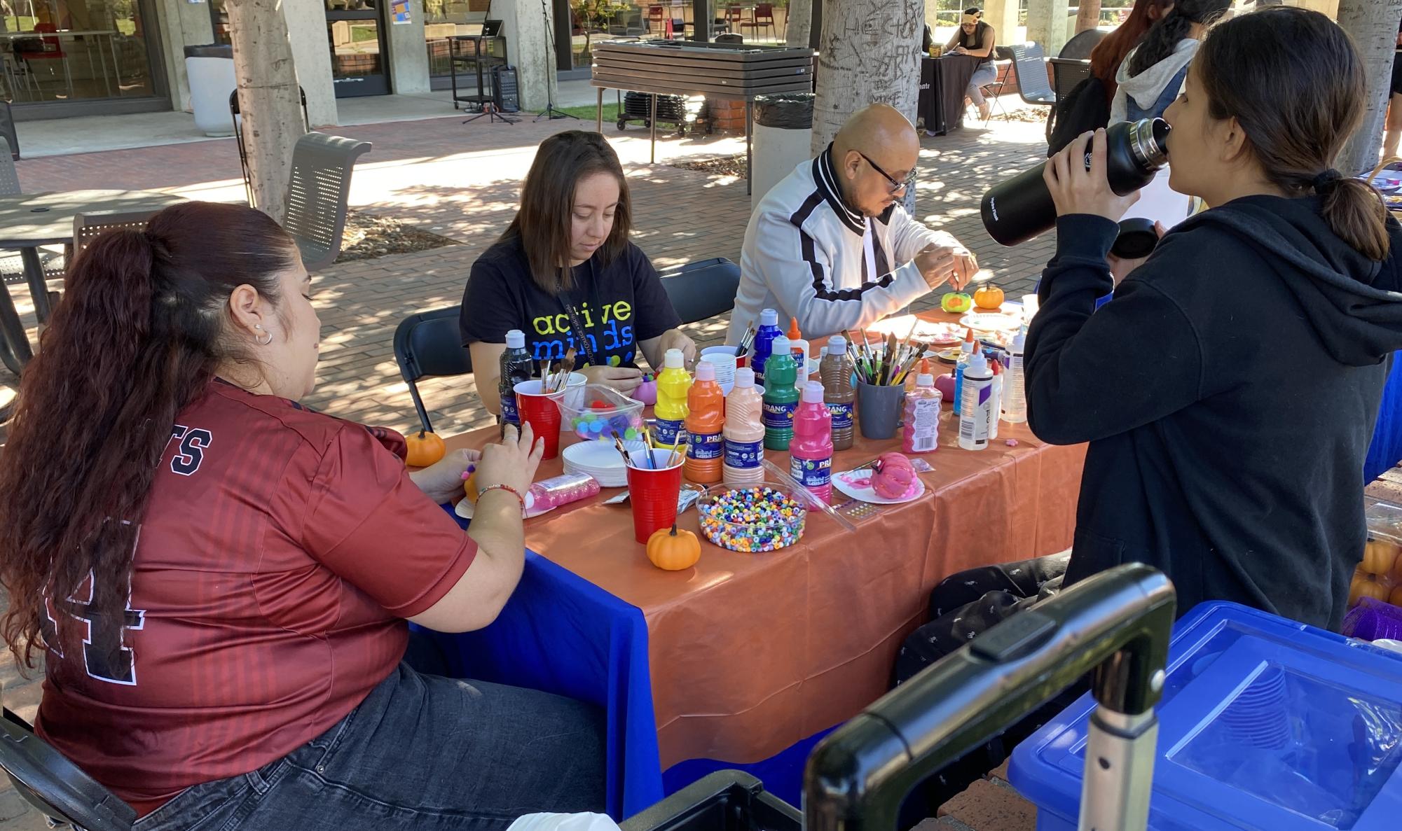 From left to right, Diana Hernandez, Nadia Sayeh, Noel Puga, and Victory Eisner decorate festive pumpkins at the Active Minds table during the San Diego City College Club Rush, Tuesday, Oct. 31, 2023. Photo by Luke Bradbury/City Times Media