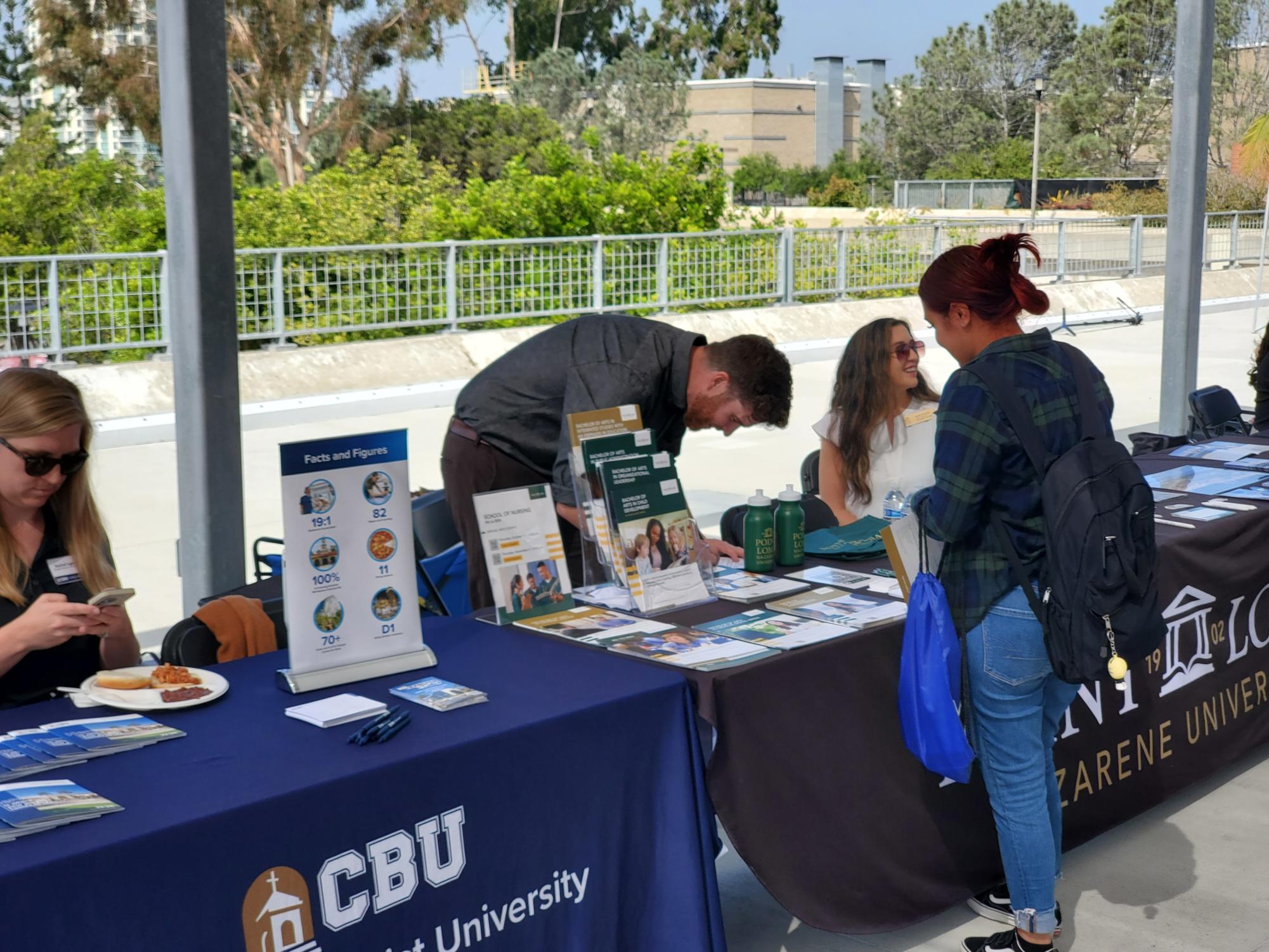 Ryon White shows an attending student promotional materials from PLNU during City College Fall 2023 Transfer Fair, Oct. 17, 2023. Vince Outlaw/City Times Media