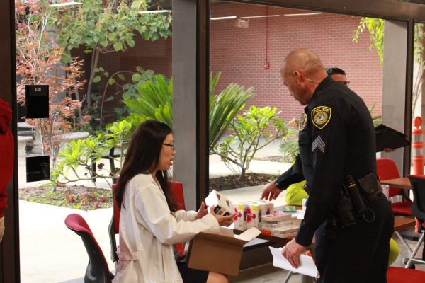 Elaine Eng, director of the student health clinic, left, hands out Narcan to Acting Lieutenant Jason Stone, right, after the first ever Health and Safety Forum on October 24, 2023. Photo by Bailey Kohnen/City Times Media