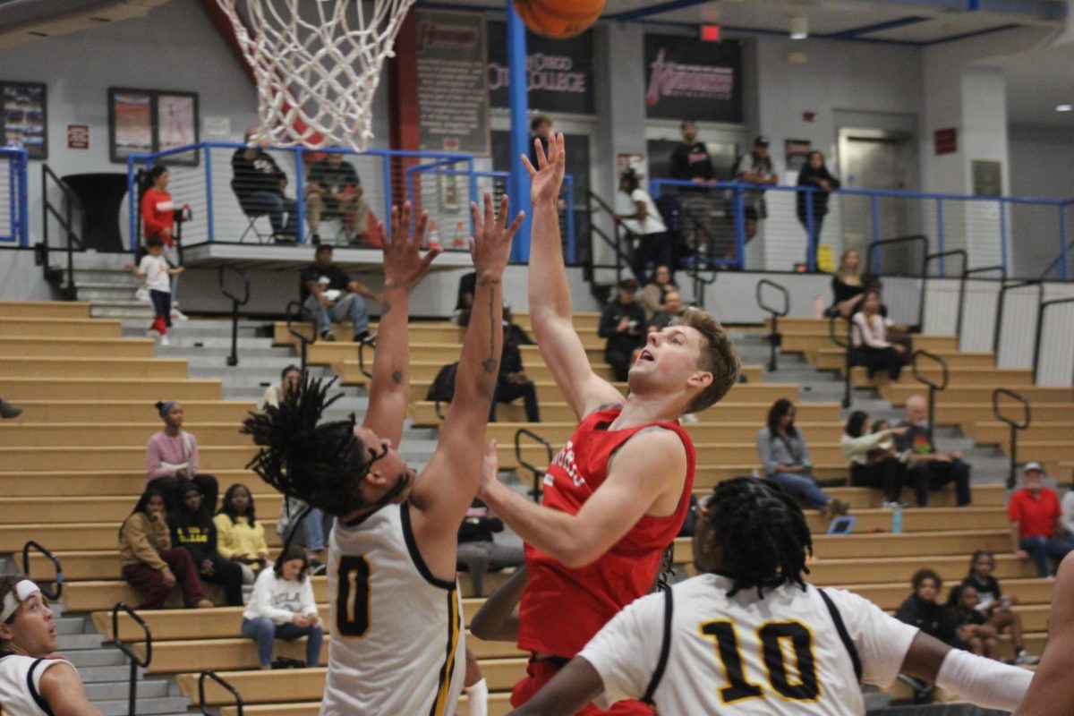 Knights basketball player Dexter Stratton, in red, shoots over a Chabot College defender in Harry West Gym, Thursday, Nov. 9, 2023. A day later, the 6-foot-8 forward came off the bench to score nine points and lead City College with six rebounds in a 77-70 loss to West Valley. Photo by Sean Monney/City Times Media