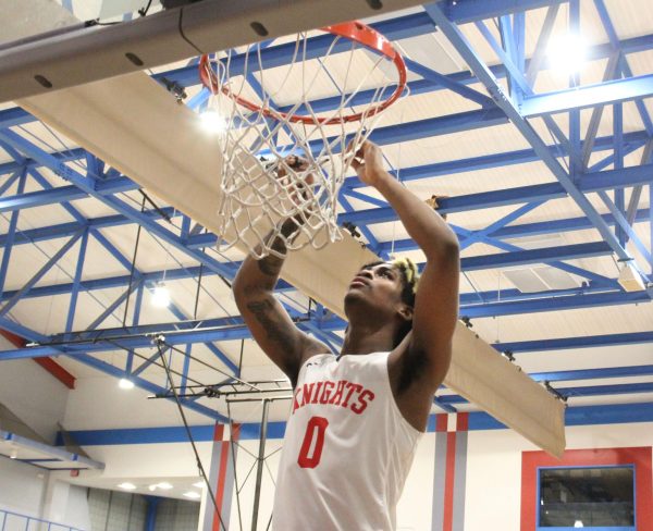 KJay Bradley (0) cuts down the net after celebrating City College’s win over Allan Handcock, clinching the school’s first Elite 8 appearance since 2018 at Harry West Gym, March 9, 2024. Photo by Danny Straus/City Times Media