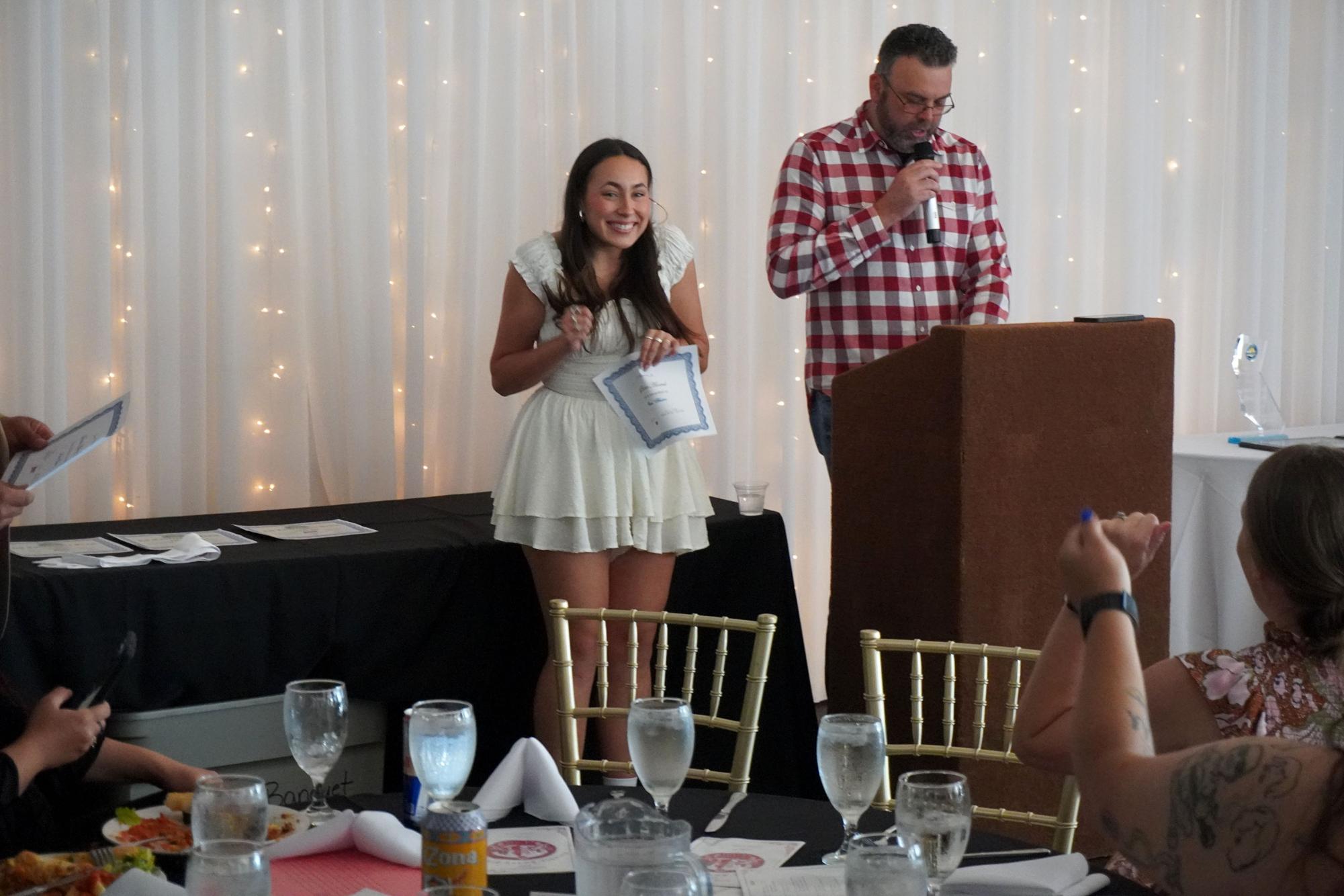 San Diego City College women’s volleyball player Josephine “Phina” Bustos, left, reacts to receiving the James Swinson Scholar-Athlete Award from Dean Aaron Detty, right, at the Knights Awards Dinner at the Marina Village Conference Center, Thursday, May 16, 2024. Phina will complete 75 academic units and has a 4.00 GPA. Photo by Vince Outlaw/City Times Media