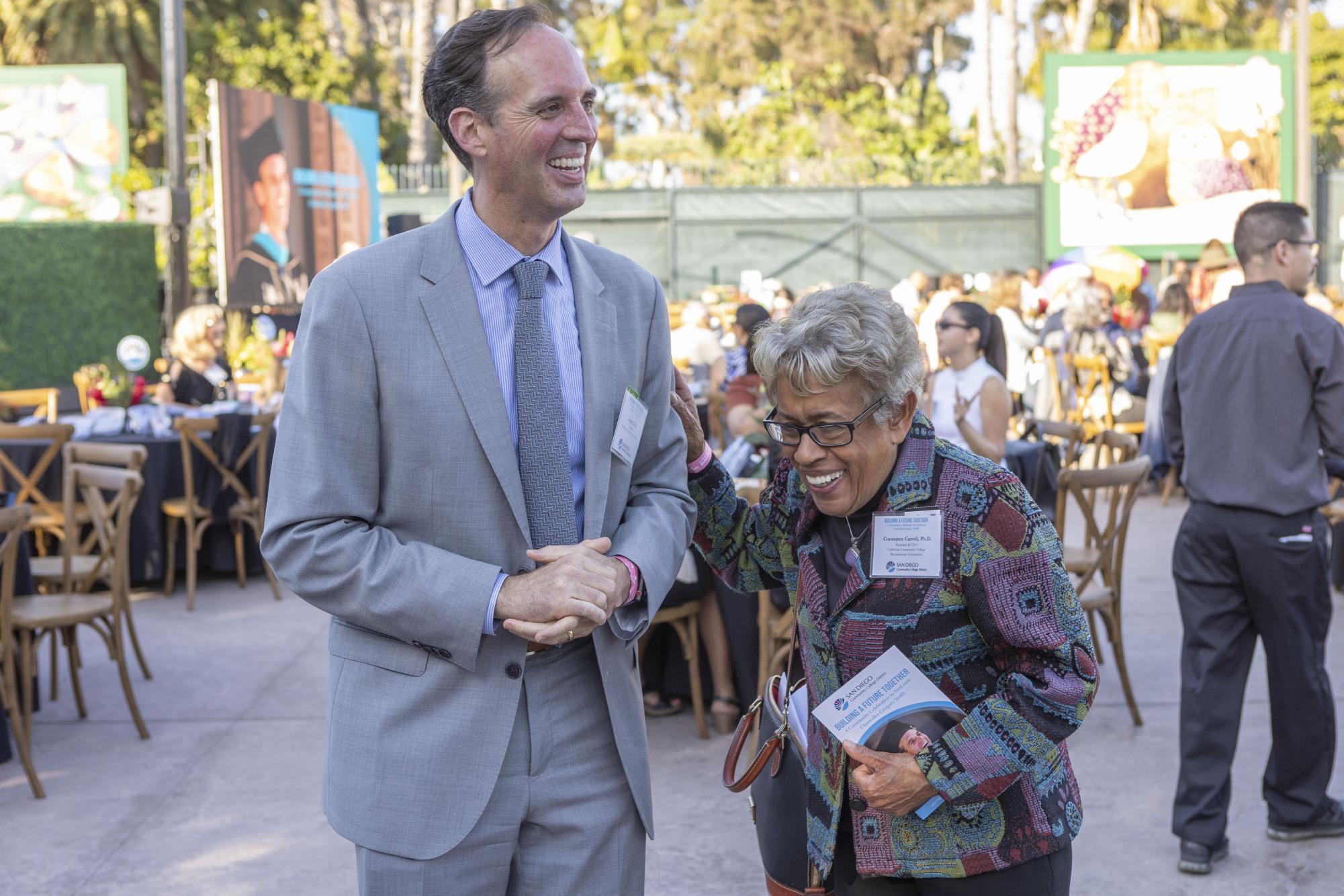 Chancellor Greg Smith, left, laughs with former Chancellor Constance Carroll, right, at Smith’s welcome celebration, June 21, 2024. Photo courtesy of SDCCD Flickr