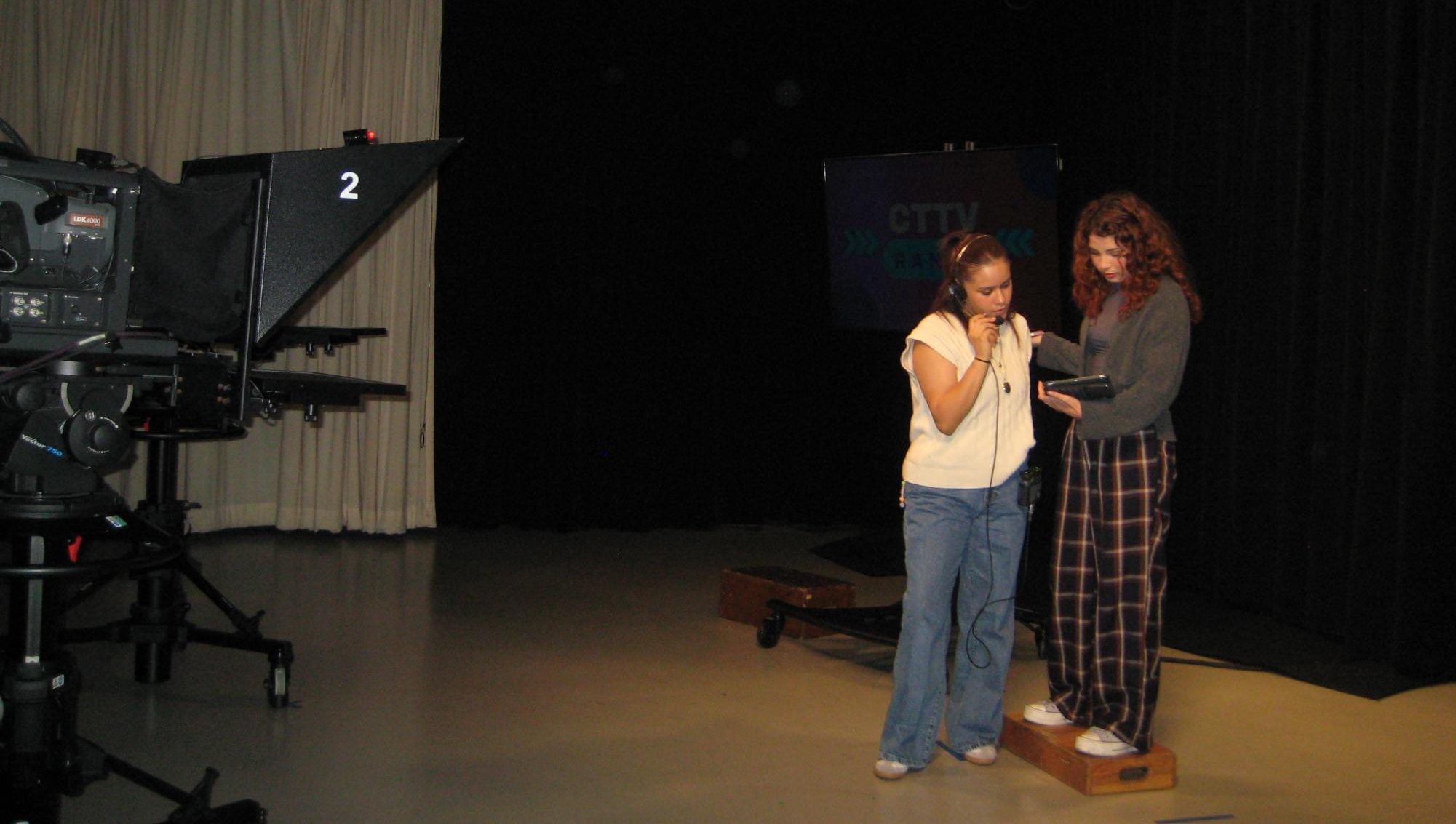 CTTV floor director Sarai Gomez, left, and "CTTV Ranks" co-host Daniela Luna, right, review the show script in the CTTV studio at San Diego City College, Friday, Sept. 27, 2024. Photo by Andrea Valdez/City Times Media