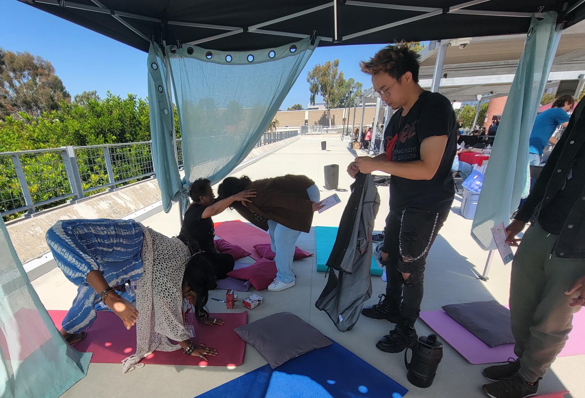 City College Student Health Services peer educator Cipriana Bethea, left, finishes leading a small group yoga session as business administration student Martin Hoang, right, gathers his belongings at the Suicide Prevention Fair held on the A Bilding Patio, Monday, Sept. 23, 2024. Photo by Jordan Bell/City Times Media
