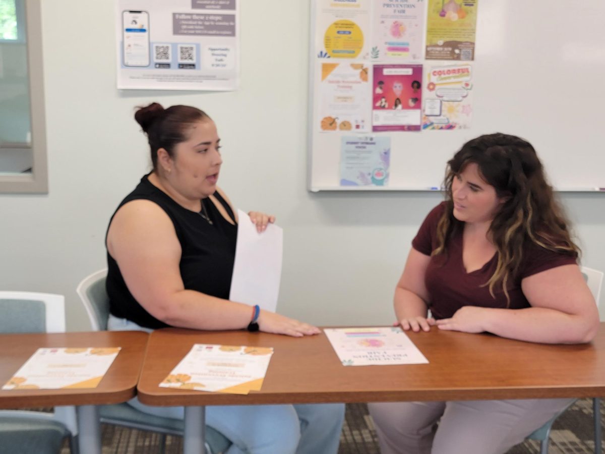 City College Student Health Center staff members Diana Hernandez, left, and Alex Felty, right, look over a poster for the upcoming Suicide Prevention Fair in their conference room, Tuesday, Sept. 17, 2024. Photo by Jordan Bell/City Times Media