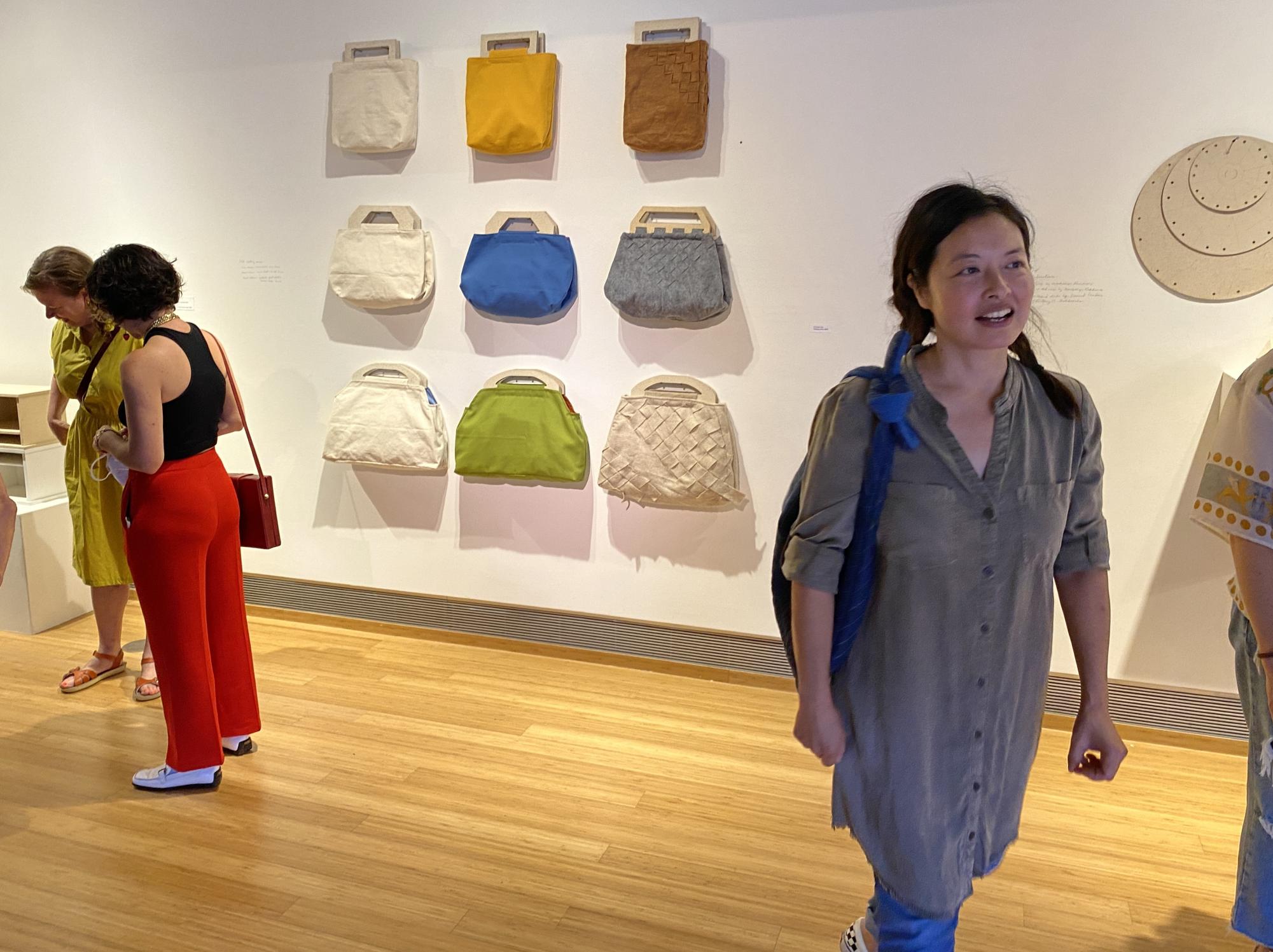 Christine Lee walks past her contribution to “Low-VOC,” Thursday, Aug. 29, 2024. The untitled set of 9 handbags are made with biodegradable materials. Photo by Luke Bradbury/City Times Media