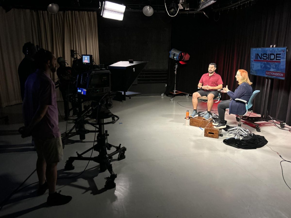 CTTV's David J. Bohnet, in red, prepares to interview City College geography professor Lisa Chaddock in the campus TV studio, Friday, October 18, 2024. CTTV's Ryan Matthysse stands behind the camera. Photo credit: FJMP photo 