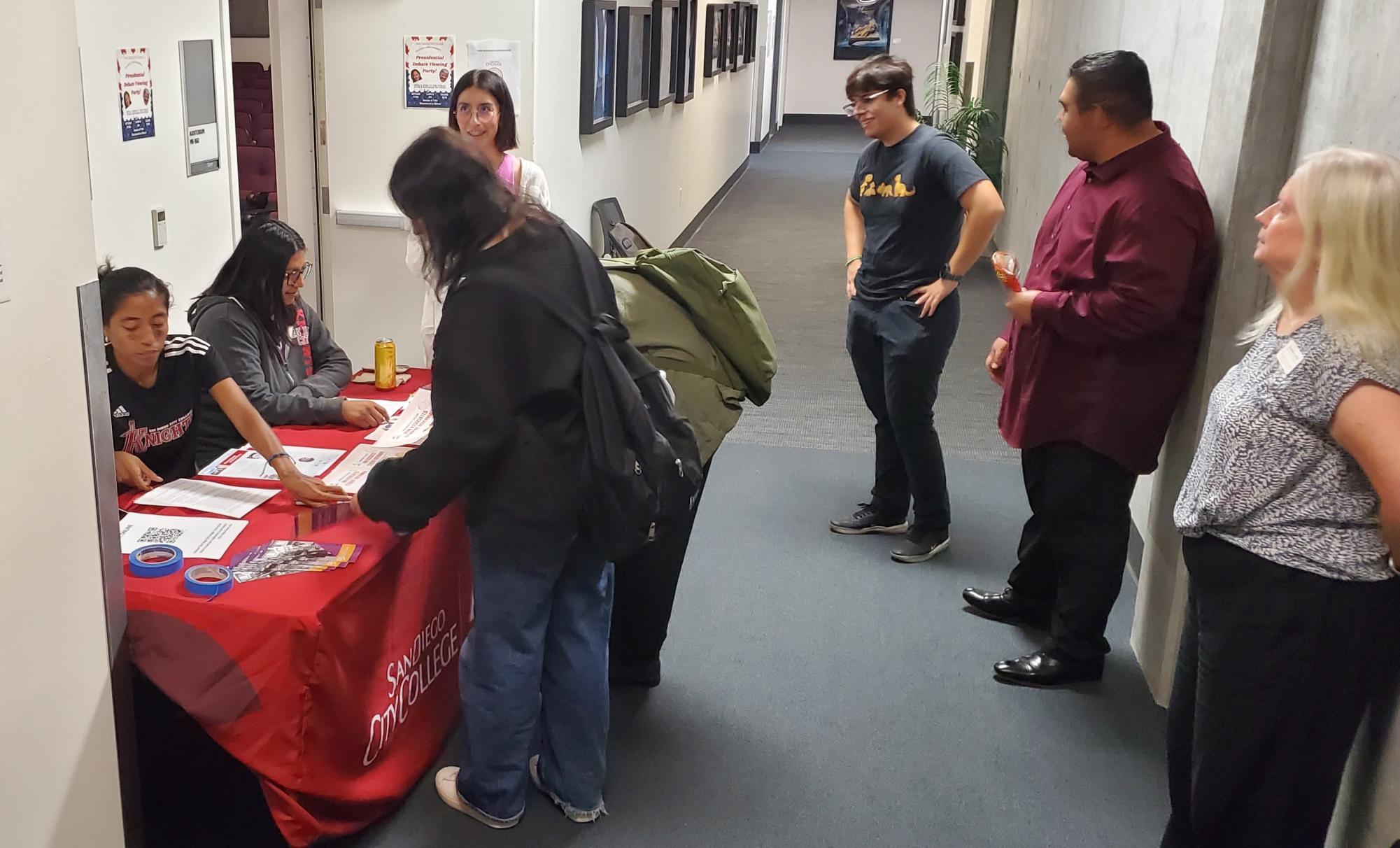 Los miembros de la junta ejecutiva del Gobierno de Estudiantes Asociados de San Diego City College, Karin Angel, izquierda, y Dalia Ramírez, segunda desde la izquierda, ayudan a registrar votantes en la Fiesta de Observación del Debate Presidencial en MS-162, el 10 de septiembre de 2024. La mesa informativa de ASG es un aspecto del Desafío de la Democracia de City College. Foto de Vince Outlaw/City Times Media