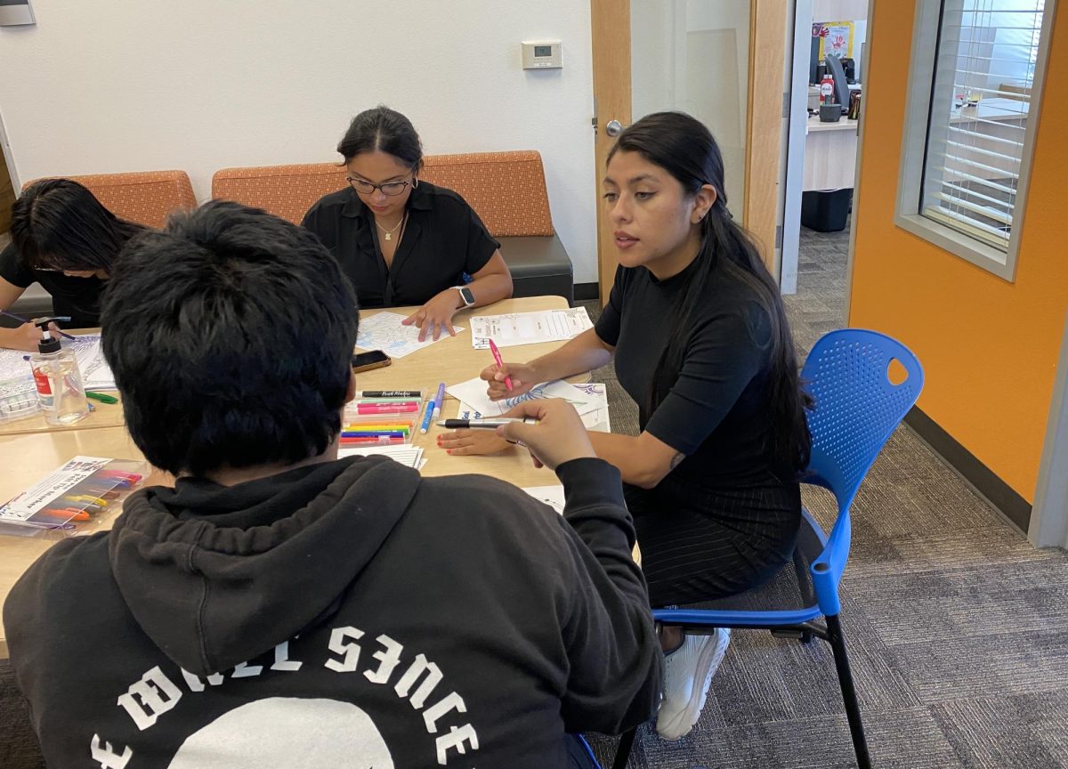 La Consejera Académica Gabriela Sotogaribay (derecha) y la Coordinadora del Programa Magaly Corro Flores (izquierda) conversan con un estudiante durante el evento Undocuchats y Crafts el jueves 9 de septiembre de 2024. Estudiantes y personal llenan libros para colorear con el fin de fomentar la comunidad. Foto por Luke Bradbury/City Times Media