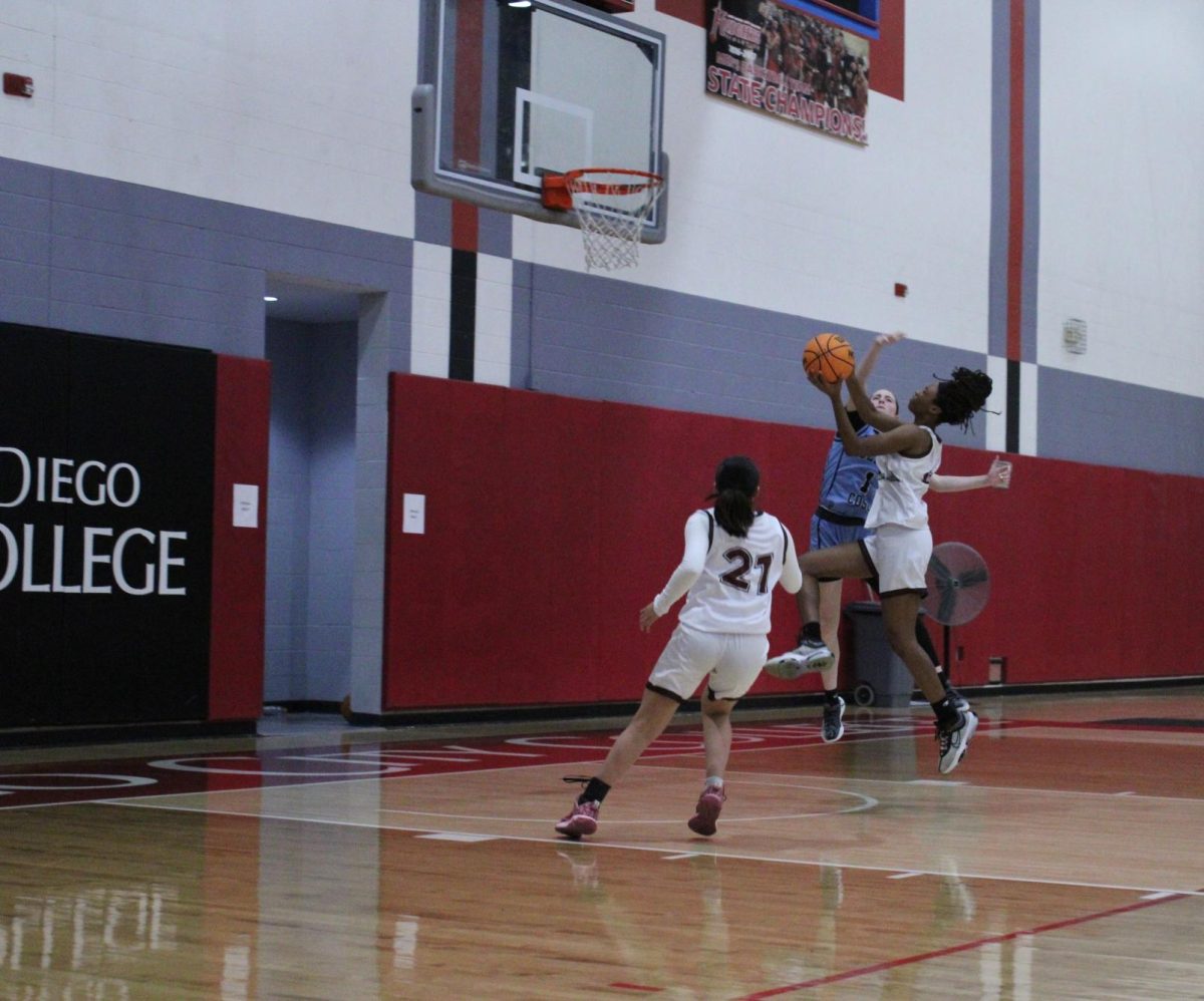 City College freshman Aamori Daniels (4) makes the layup while being fouled by Savannah Rowland (1) against Cerra Coso at Harry West Gym, Thursday, Nov. 21, 2024.