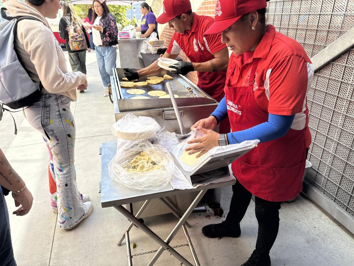 Damien Laguna, left, and Carla Perez, right, cook fresh quesadillas for participants at the Día de los Muertos campus event Wednesday, Oct. 30, 2024. Photo by Luke Bradbury/City Times Media