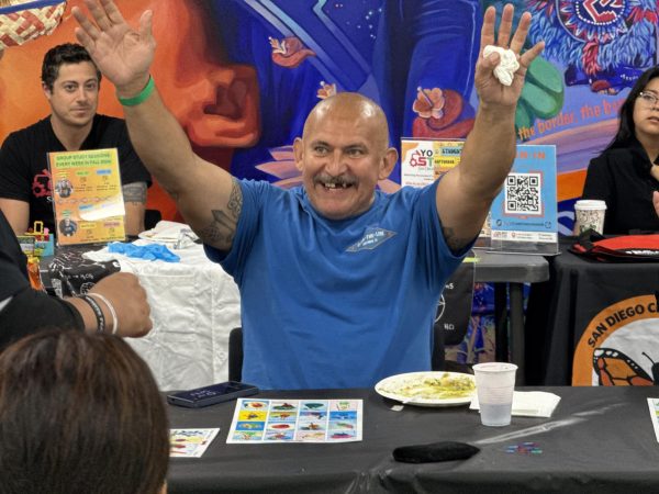 Moses Pinon, 57, celebrates his victory at lotería during the Día de los Muertos campus event Wednesday, Oct. 30, 2024. Photo by Luke Bradbury/City Times Media
