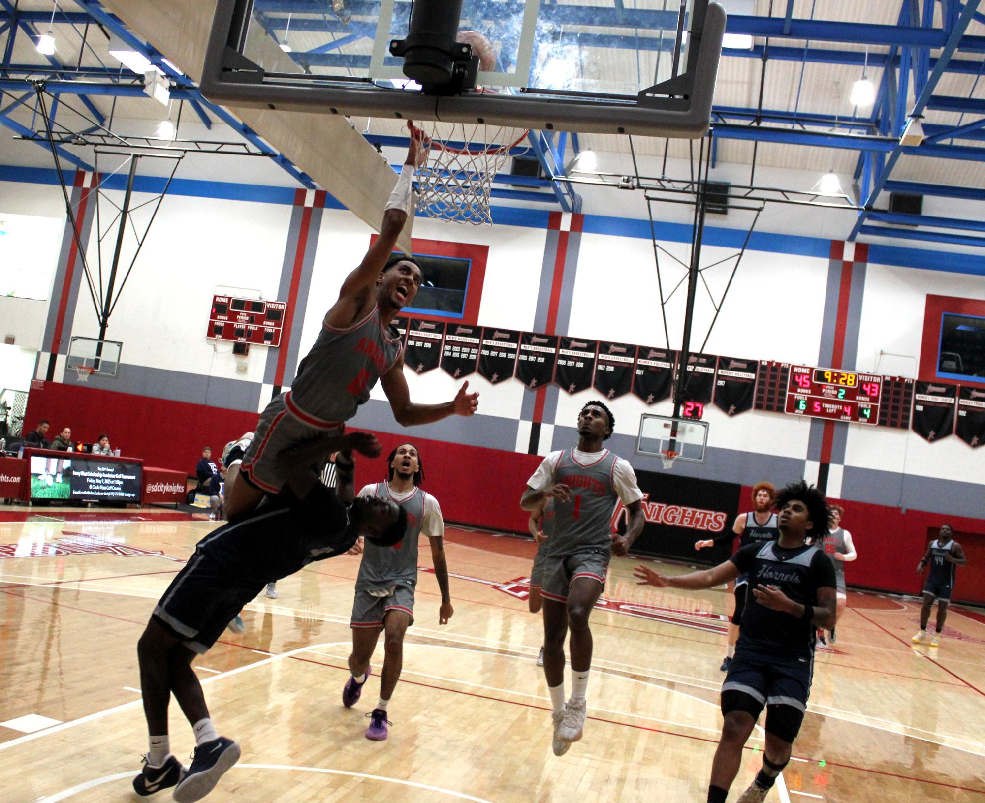 City College sophomore guard Logan Huston (11) attempts to dunk over Fullerton College guard Justin Davis (4) in the second half of City’s 61-58 loss to Fullerton at Harry West Gym, Saturday, Nov. 30, 2024. Photo by Danny Straus/City Times Media 
