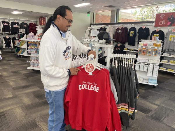 City College bookstore supervisor Sol Madrid hangs merchandise at the campus bookstore on Monday, December 6, 2024. Photo by: David J. Bohnet/City Times Media
