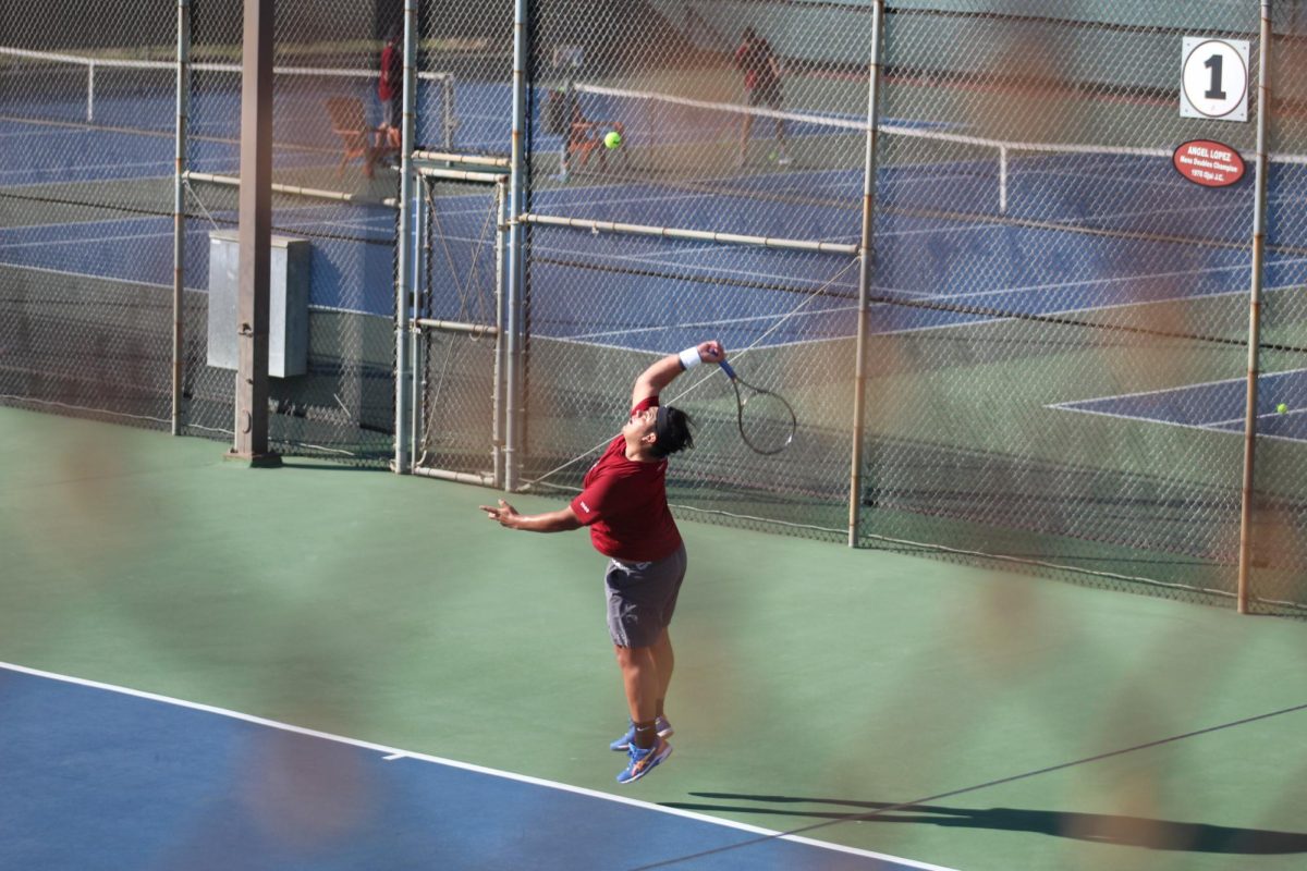 City men’s tennis player Abel Martinez Mosqueda smashes a serve in the final singles matchup, winning the tie breaking set 10-5 on Friday, Feb. 20, 2025. Photo by David J. Bohnet/City Times Media
