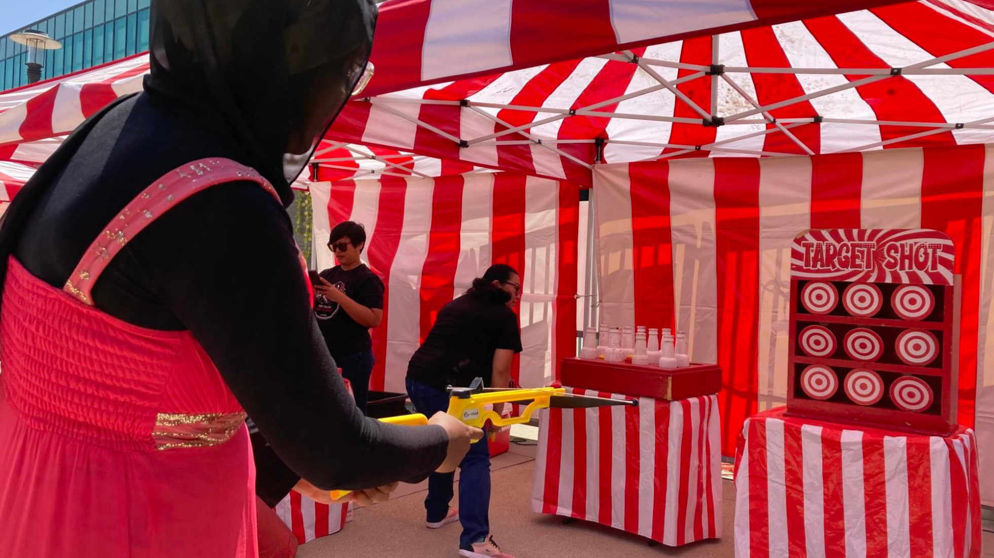 Second-year international business student Amal Mohamed Bashir shoots at targets in a crossbow game at the Club Rush Carnival, August 24, 2023. Bashir said she took a break from tabling at the event on behalf of the Muslim Students Association and ASG. Photo by Marco Guajardo/City Times Media